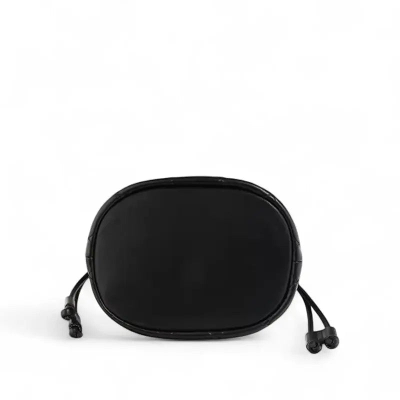 Vista da base da bolsa feminina Selene em couro legítimo preto, destacando formato oval e alças finas