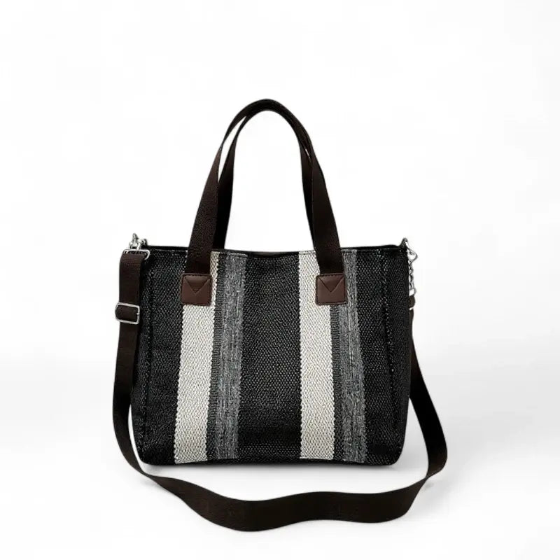 Bolsa feminina transversal listrada em tecido resistente, com alça longa removível, ideal para uso diário e compras. Estilo elegante e moderno em tons de preto, cinza e branco.