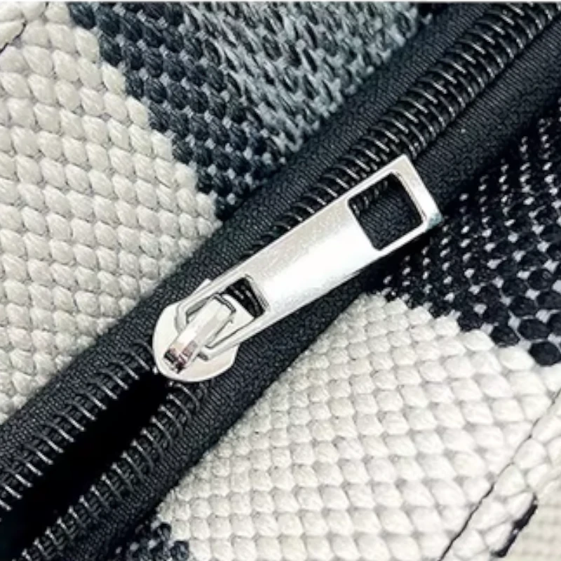 Detalhe do zíper metálico resistente da bolsa feminina listrada, com acabamento elegante e durável. Ideal para manter seus pertences seguros e organizados