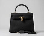 Bolsa Catarina preta vista de frente com foco no fechamento frontal icônico de encaixe dourado