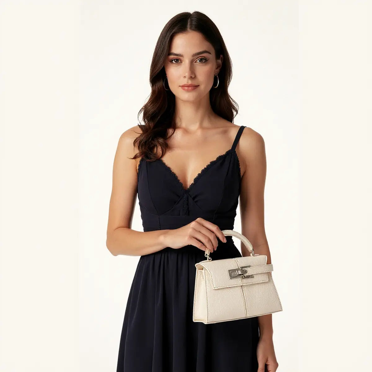 Modelo com vestido preto segurando a bolsa feminina Elise bege, elegante e compacta