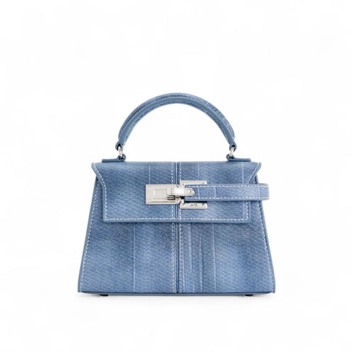 Bolsa feminina estruturada pequena em jeans azul, vista frontal com detalhe em fecho metálico