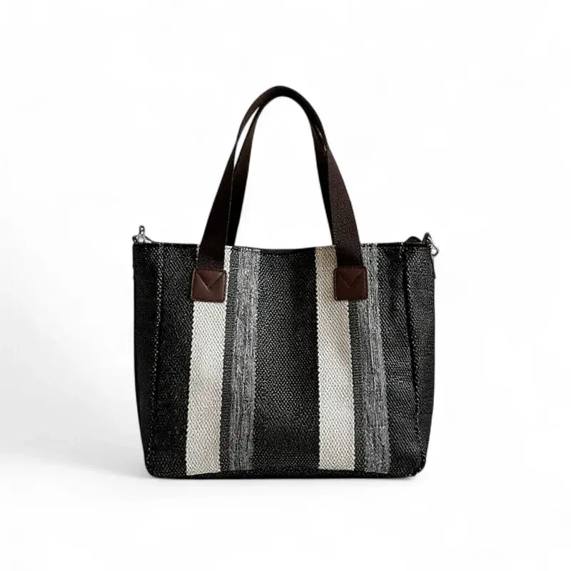 Bolsa feminina grande com alças curtas e design listrado em preto, cinza e branco. Feita em material resistente, perfeita para carregar itens do dia a dia com estilo.