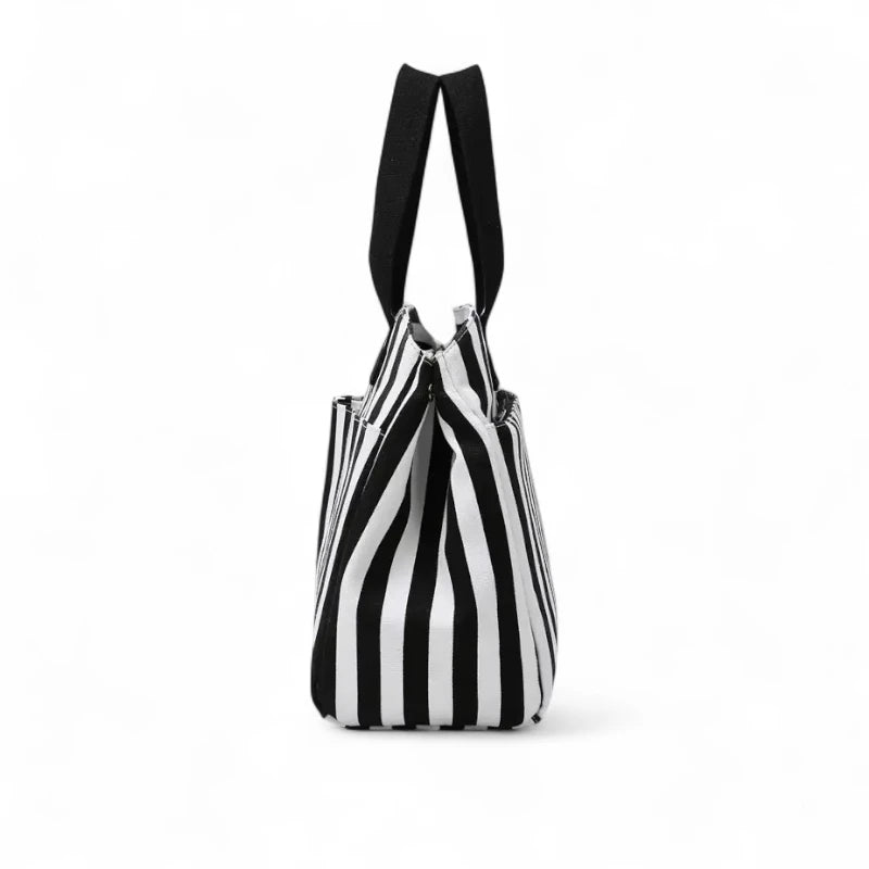 Lado da bolsa feminina para trabalho e maternidade com costura reforçada e formato ergonômico. Espaço interno amplo para organizar roupas, laptop, fraldas e outros itens essenciais.