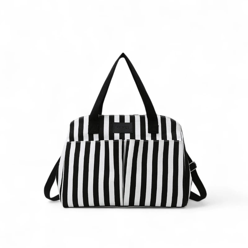 Bolsa feminina para trabalho e maternidade em listras pretas e brancas, com alças curtas e alça transversal removível. Design elegante e funcional para levar notebook, documentos, fraldas e acessórios.