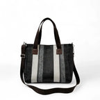 Bolsa feminina transversal listrada em tecido resistente, com alça longa removível, ideal para uso diário e compras. Estilo elegante e moderno em tons de preto, cinza e branco.