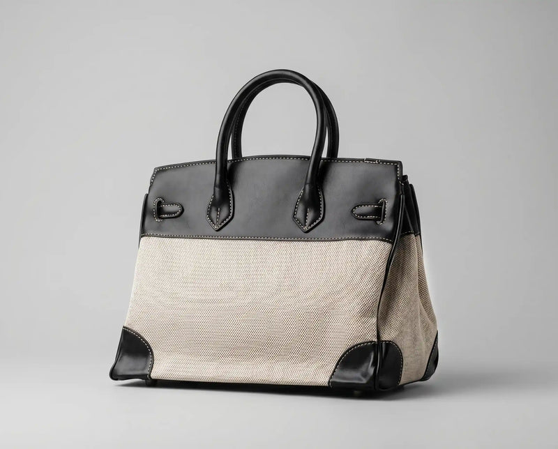 Vista traseira em diagonal da bolsa feminina em canvas e preto com alças de mão estruturadas