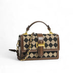 Bolsa transversal feminina Isabela marrom com estampa de losangos pretos e alça de corrente dourada.