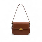 Bolsa transversal feminina marrom de tamanho médio com fecho dourado e alça ajustável.