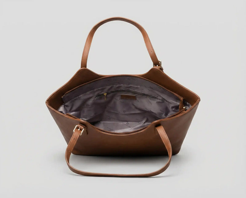 Detalhe do interior de bolsa feminina Velucci com forro em tecido acetinado cinza, bolso interno com zíper e amplo espaço organizacional.