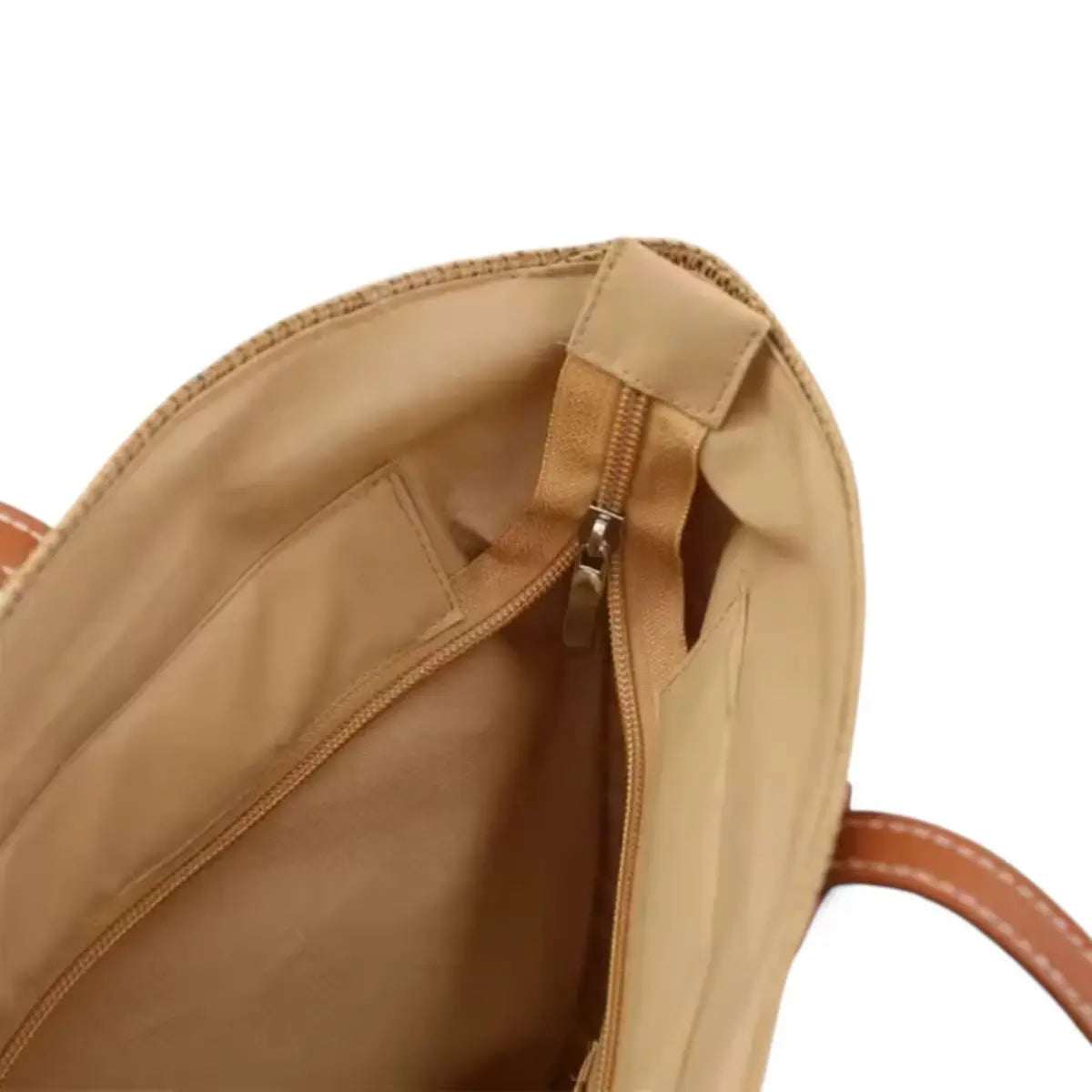 Interior de bolsa feminina de palha grande com forro bege e bolso com zíper.