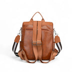 Vista traseira da mochila feminina marrom com alças acolchoadas e fechos metálicos. Design ergonômico para conforto durante longos deslocamentos.
